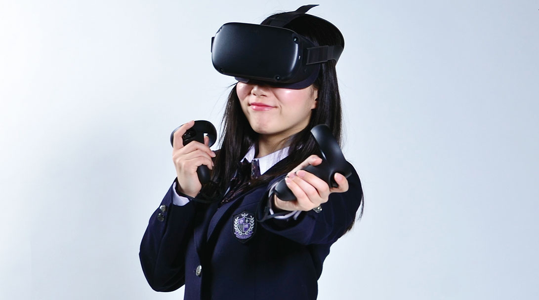 VRゴーグルをつけてこちらを見る学生