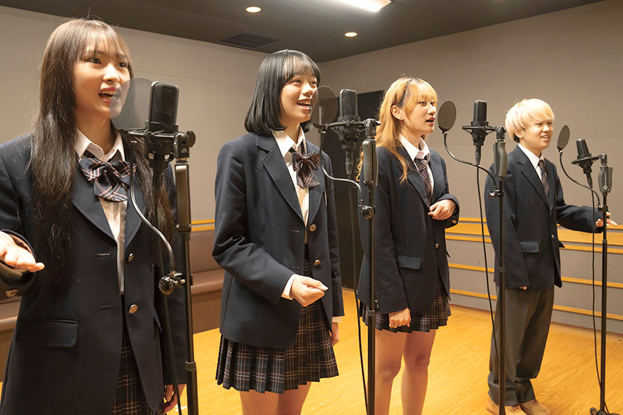 マイクに向かって声を話す学生
