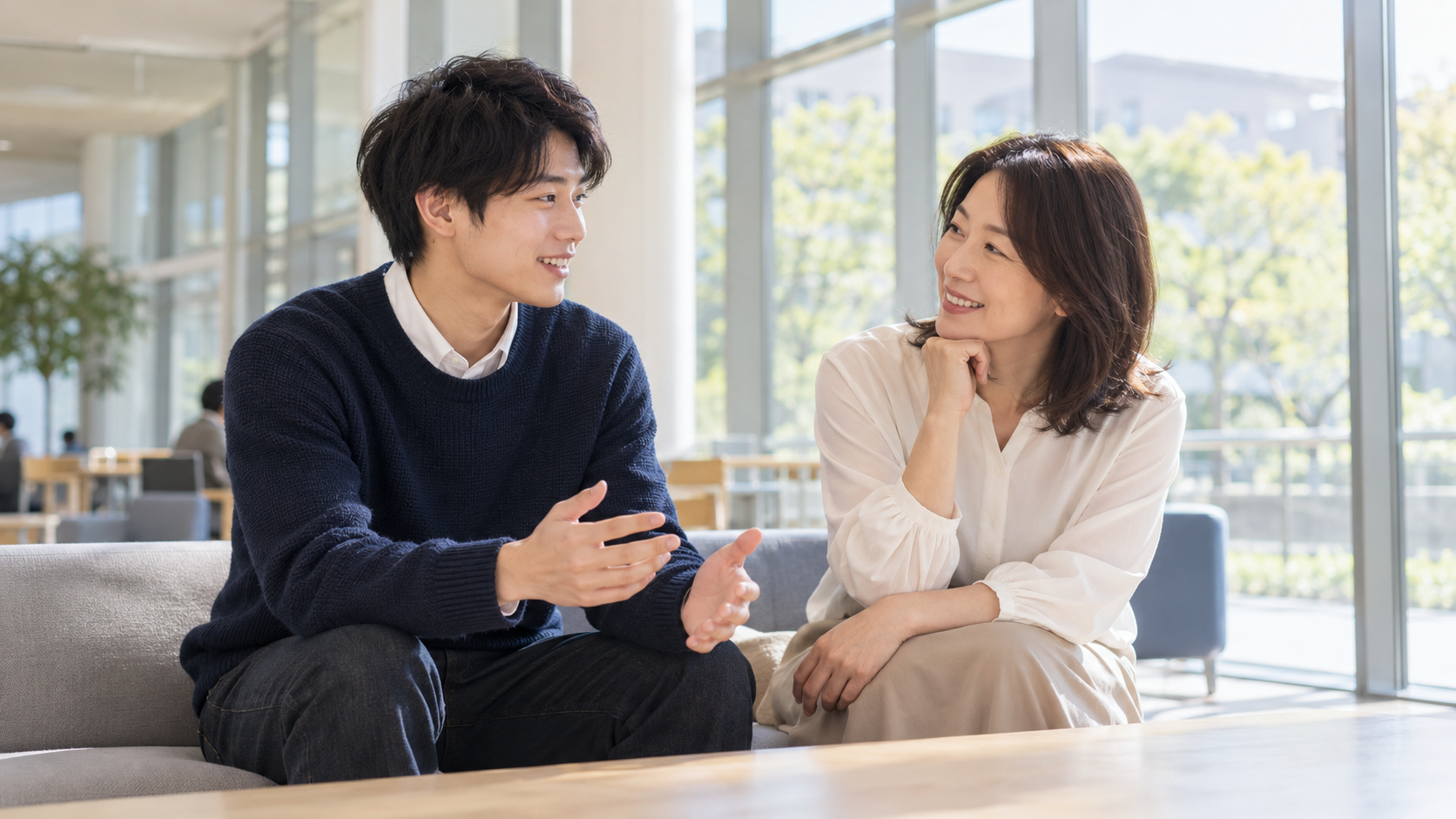 学校のロビーで進学を話し合う男性と母親のイメージ