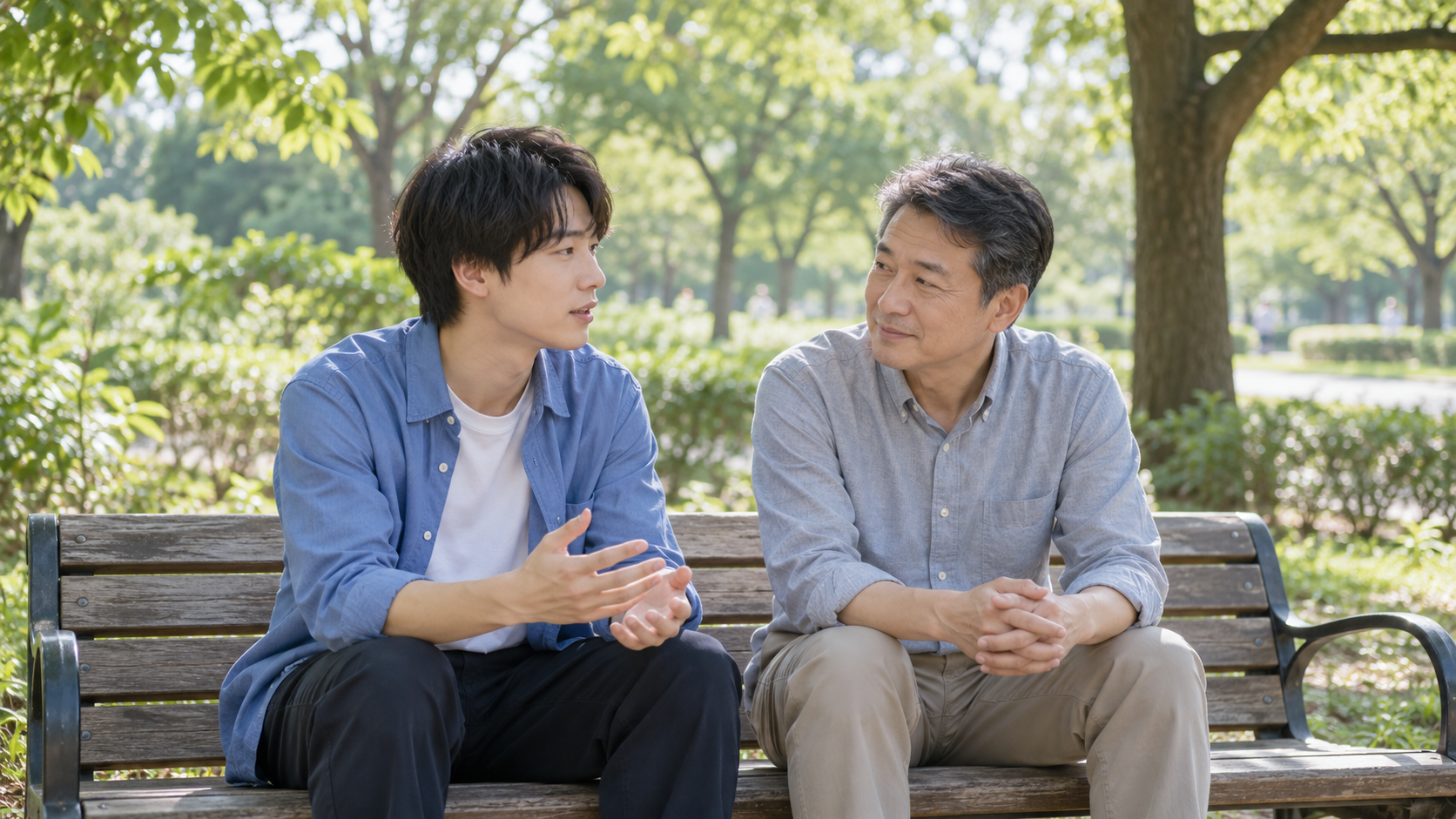 公園のベンチで進路を話し合う男性と父親のイメージ